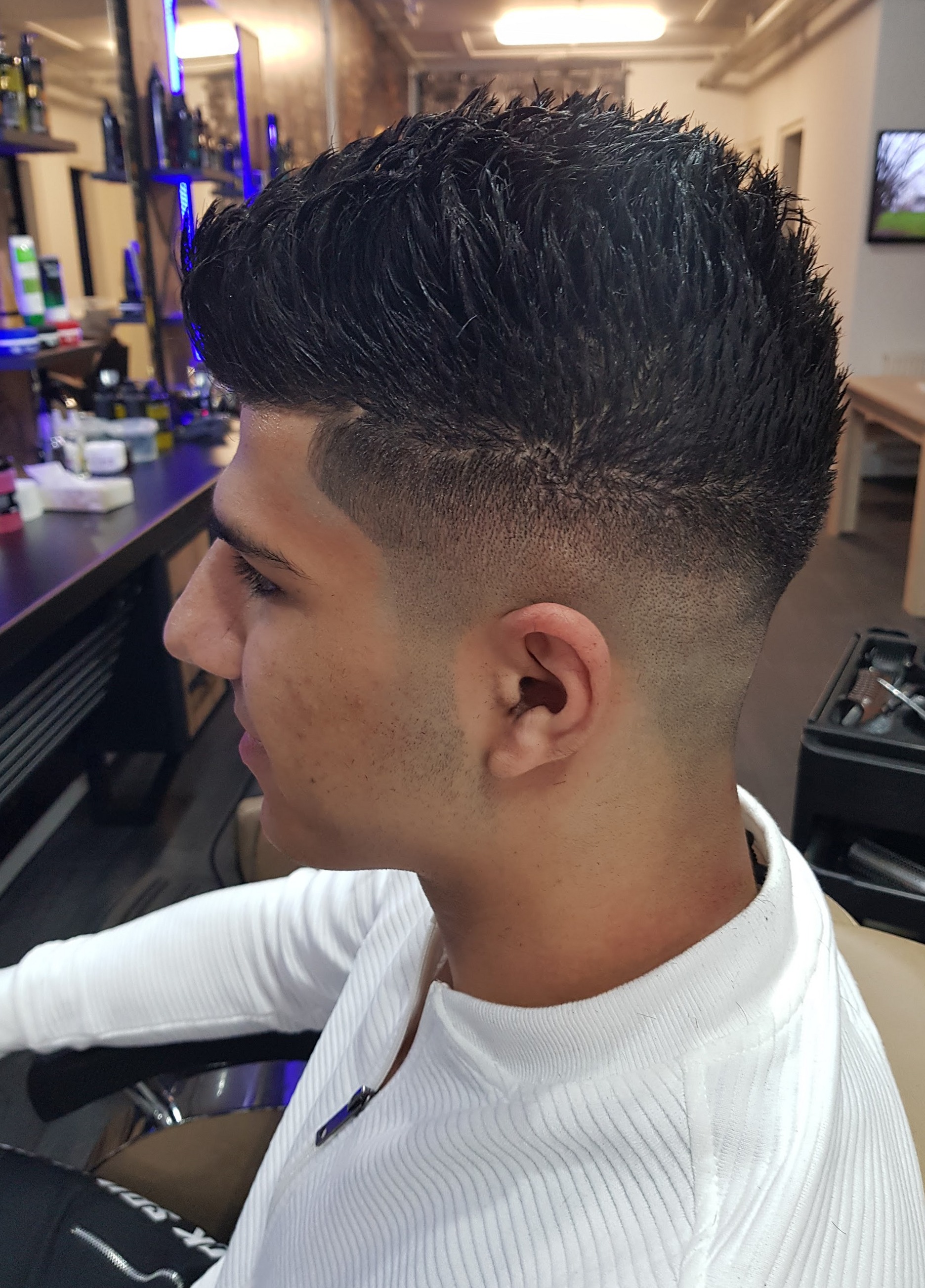 Klant van opzij met een kuif met textuur en een skin fade