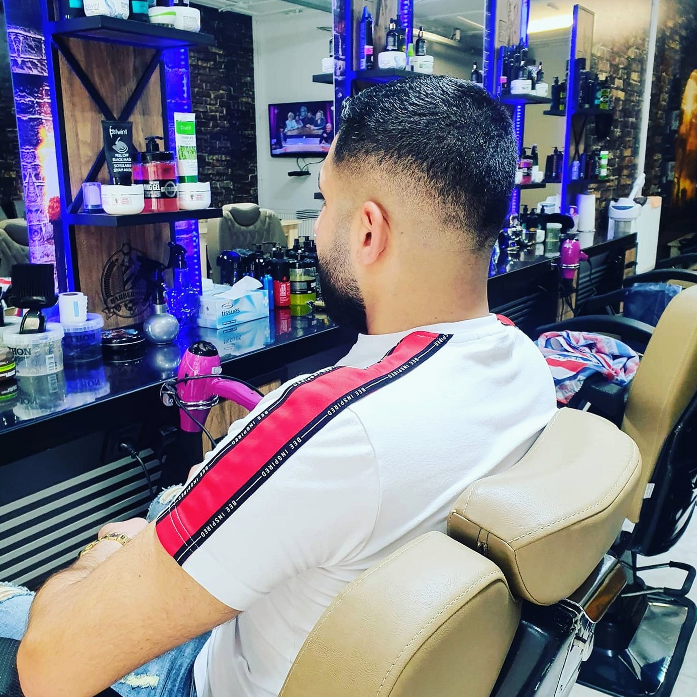 Klant in de lichtbruine kappersstoel met een strakke fade