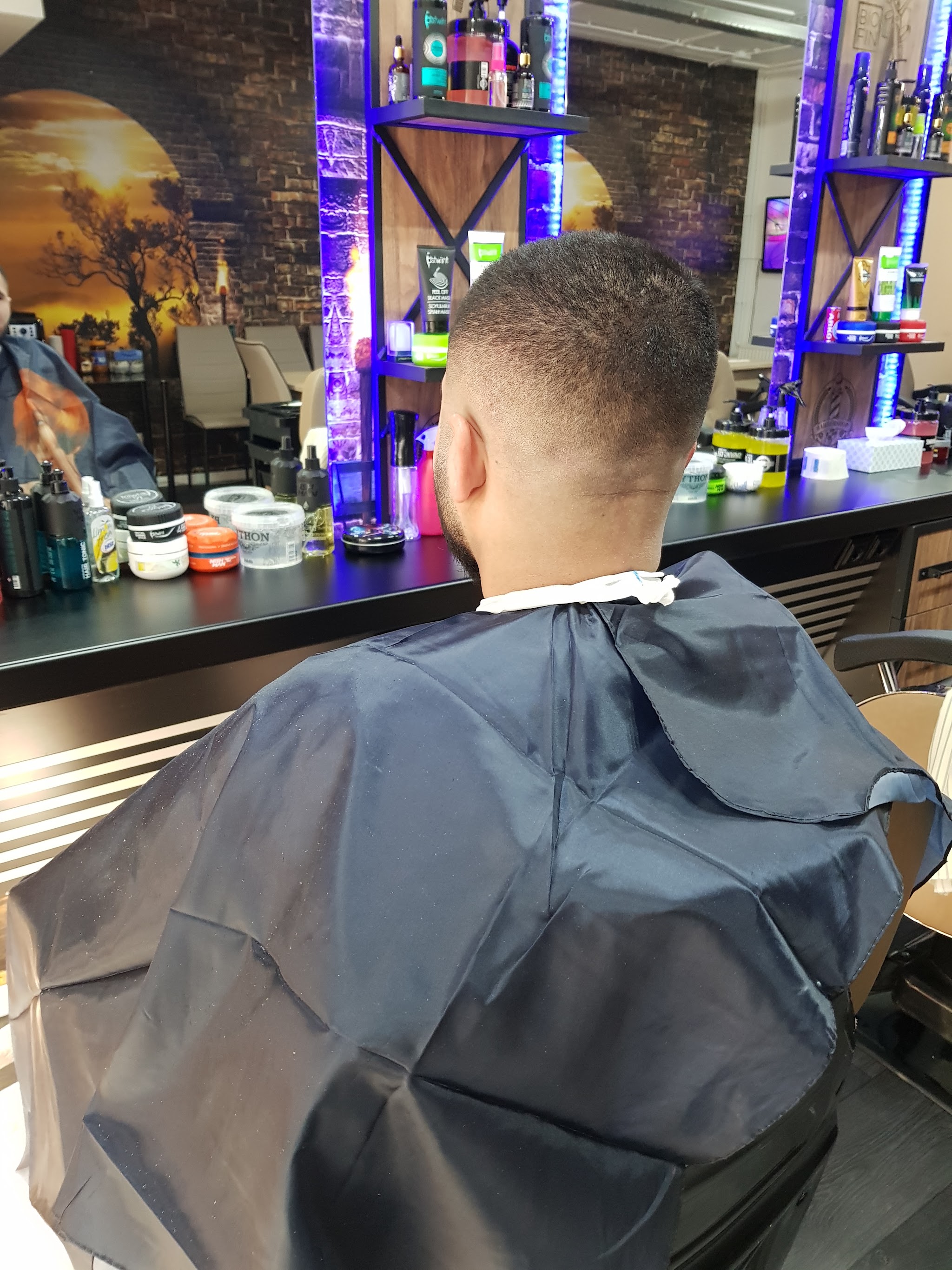 Een vers geknipte fade onder de blauwe ledverlichting van de schappen